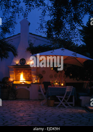 Dach über dem Tisch mit Glas Kerze Laternen auf der Terrasse der Villa auf der Insel Korfu in der Nacht Stockfoto