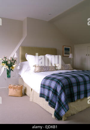 Blau karierte Wolldecke auf Polsterbett mit weißen Kissen in blass grau modernen Schlafzimmer gefaltet Stockfoto