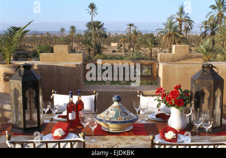 Laternen am Tisch für das Mittagessen mit einer Tajine und rose Wein auf der Dachterrasse der Villa in Marokko Stockfoto