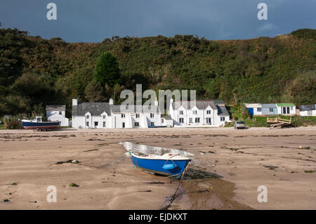 Kleines Boot vor weißen Häusern am Nefyn Strand auf der Halbinsel Leyn, Nordwales. Ein sonniger Morgen. Stockfoto