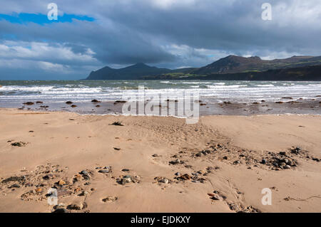 Nefyn Strand auf der Lleyn-Halbinsel in Nord-Wales. Ein Sandstrand an einem sonnigen Morgen mit den Umriss der Hügel entlang der Küste. Stockfoto