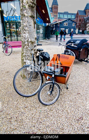 Fahrräder mit angehängten, Bakfiets, Karren Kindertrage in Amsterdam. Dies ist eine gemeinsame & beliebte Transportmittel in dieser Stadt. Stockfoto