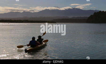 Kajakfahrer Okarito Lagoon Neuseeland mit südlichen Alpen Berge im Hintergrund Stockfoto