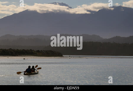 Kajakfahrer Okarito Lagoon Neuseeland mit südlichen Alpen Berge im Hintergrund Stockfoto