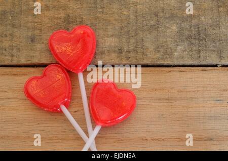 Herzförmige Lollis auf Palette holz Hintergrund angezeigt. Festive Fun Design zu Feiertage oder Geburtstage, Romantik, Valentinstag feiern. Stockfoto