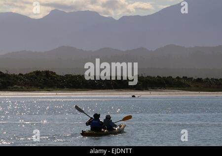 Kajakfahrer Okarito Lagoon Neuseeland mit südlichen Alpen Berge im Hintergrund Stockfoto