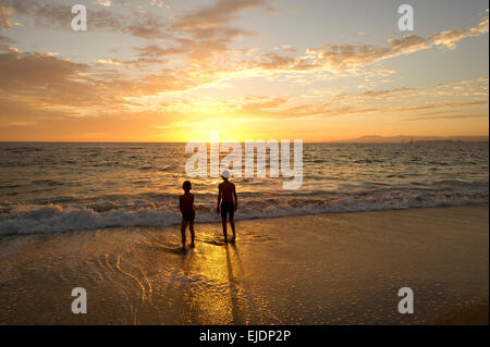 Zwei Jungs genießen Sie den Sonnenuntergang auf dem Wasser. Stockfoto