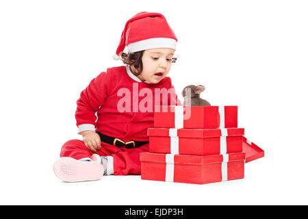 Entzückende Babymädchen im Weihnachtsmann-Kostüm Eröffnung Weihnachten präsentiert Stockfoto