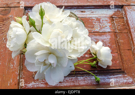 Schöner Blumenstrauß Rosen mit Tropfen auf alten Holztisch. Nach dem Regen. Draufsicht. Rustikalen Stil. Stockfoto