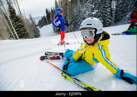 Junges Mädchen liegend auf der Piste Stockfoto