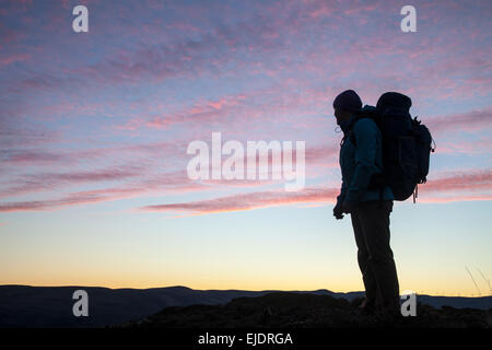 Eine Frau trägt einen Rucksack findet in den Sonnenuntergang an der Franzose Coulee, Washington. Stockfoto