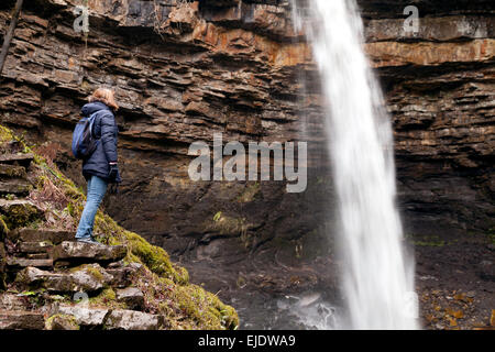 Frau Wanderer betrachten Hardraw Force Wasserfall, North Yorkshire Dales, England UK Stockfoto