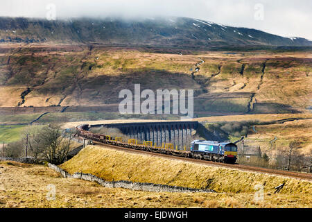 Ein Güterzug überlässt Ribblehead-Viadukt auf der Settle Carlisle Bahnstrecke, North Yorkshire. Whernside im Hintergrund. Stockfoto