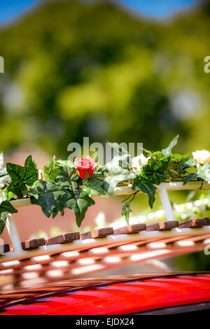 Einem hellen roten VW Camper Bus für eine Hochzeit vorbereitet. Stockfoto