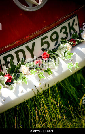 Einem hellen roten VW Camper Bus für eine Hochzeit vorbereitet. Stockfoto