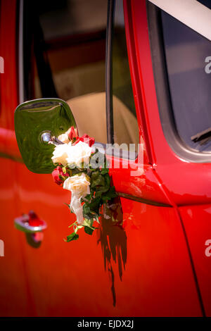 Einem hellen roten VW Camper Bus für eine Hochzeit vorbereitet. Stockfoto