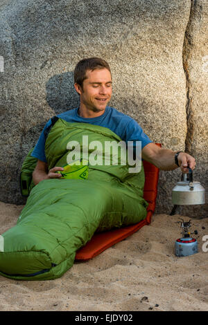 Mann in einem Schlafsack Heizungswasser Stockfoto