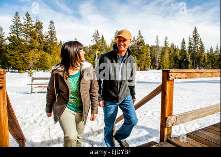 Paare, die das Kartenspiel mit Schnee im Hintergrund Stockfoto