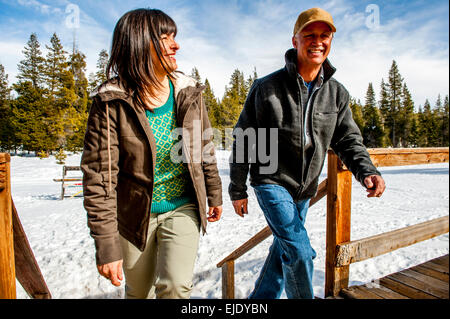 Paare, die das Kartenspiel mit Schnee im Hintergrund Stockfoto