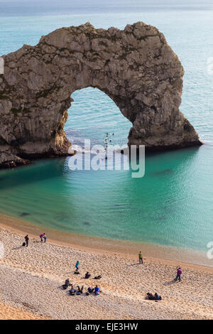 Das Meer Arch bei Durdle Door an der Jurassic Coast in Dorset auf einem ruhigen, sonnigen Tag. Schwimmer schwimmen durch den Torbogen. Stockfoto