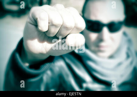 Nahaufnahme eines jungen Mannes in einem Protest heben seine Faust und mit seinem Gesicht verschwommen, mit einem Filtereffekt Stockfoto