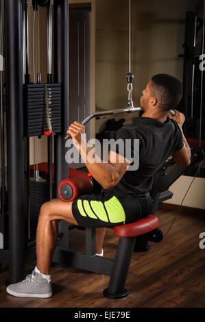 Junger Mann dabei Lats Pulldown-Training Stockfoto