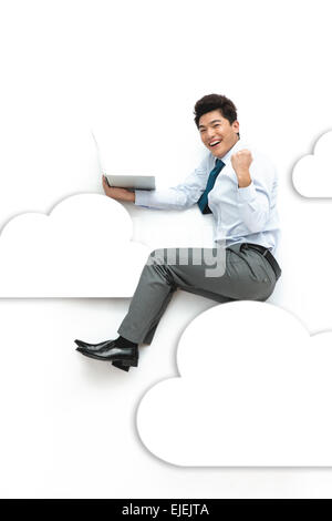 Der Business-Mann saß mit einem Notebook-Computer in der cloud Stockfoto