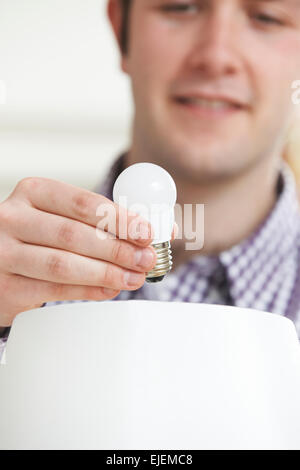 Menschen setzen Low Energy LED Glühbirne in Lampe zu Hause Stockfoto