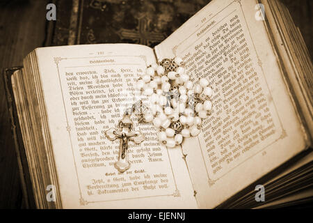 Vintage Kreuz mit Jesus Figur auf Seiten der geöffneten Bibel, sepia Stockfoto