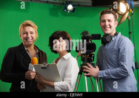 Porträt von Kameramann mit Moderatorin und Aufnahmeleiter im Fernsehstudio Stockfoto