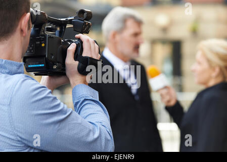 Kameramann Aufnahme Journalistin interviewt Geschäftsmann Stockfoto