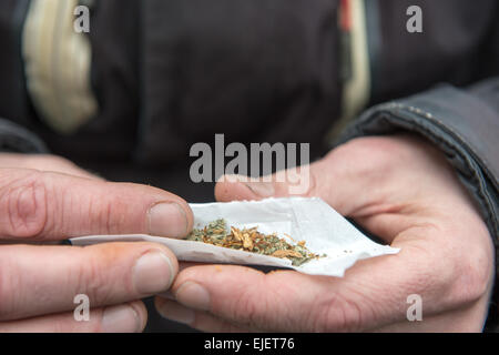 Ein Mann, der einen Joint mit Happy Joker, Legal High Stockfoto