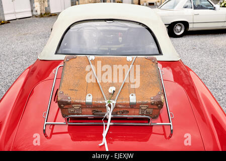 Koffer in den Kofferraum ein rotes Auto gebracht Stockfoto