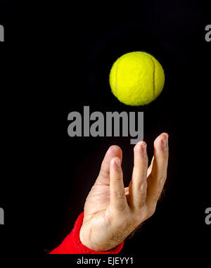 Nahaufnahme des Mannes Hand, Arm, warf den Tennisball Durchführung dienen. Tennis dienen. Spieler auf den Wettbewerb. Isoliert auf schwarz Stockfoto