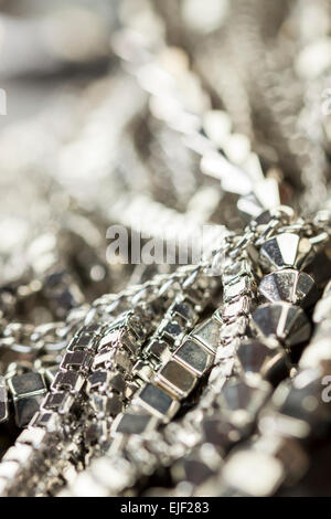 Verschiedene Silber Modeschmuck mit einem Durcheinander Haufen Ketten mit verschiedenen geformten Links, einem klaren Kristallperle und eine Halskette Stockfoto