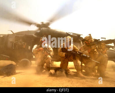 US-Armee Soldaten vom 1. Bataillon, 41. Infanterie-Regiment, 3. Brigade, 1. US-Panzerdivision scannen die Landezone für möglichen feindlichen Kräfte 26. August 2005. Die Soldaten bereitgestellt eine Sicherheit-Cordon, so dass ihre Einheit einen Spielturm für eine lokale Schulhof im nördlichen Bagdad aufbauen konnten. Die Mission wurde treffend benannt Betrieb Jungle Gym.  US Air Force Tech Sgt. Russell E. Cooley IV.      . Stockfoto