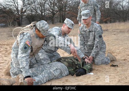 US Army Spc. Jeter, Zentrum, mit der 302. Military Intelligence Battalion, zeigt Sgt. Jones und Pfc. Rayburn, wie erste Hilfe für einen verletzten Soldaten während des Trainings im Bereich Wiesbaden Sanddünen Ausbildung in Mainz, Deutschland, 28. Februar 2008 durchführen.  Volker Ramspott veröffentlicht Stockfoto