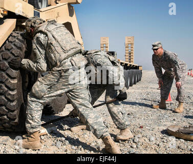 Dritte Armee US Army Spc. Skyler Reed und Sgt. Mitchell Brahms montieren ein Reifens auf ein schweres Gerät Transport beim 180. Transport-Bataillon LKW Rodeo auf Camp Arifjan, Kuwait, 3. Dezember 2009. Die zeitgesteuerte Wettbewerb Zweierteams in sechs der häufigsten Schwierigkeiten auf der Straße getestet. Die Soldaten sind die 443rd Transport-Unternehmen und eine Armee-Reserve-Einheit mit Sitz in Lincoln, Nebraska zugeordnet  SPC. Monte Swift Stockfoto