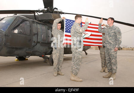 SPC. Jeffrey Anderson Recht, ein Black Hawk Hubschrauber Crewchief, Unternehmen B, 3. Bataillon, 4. Aviation Regiment, Combat Aviation Brigade, 4. US-Infanteriedivision, von Salinas, Kalifornien, rechts, reenlists am 14. Februar auf dem Camp Taji Flugplatz vor ein Black Hawk-Hubschrauber als Captain Benjamin Watt links, Executive Officer von Co. B aus Los Angeles, las ihm den Eid. Mit nur fünf Monate nach Beginn der Mission Geschäftsjahr 2009 war Anderson der Soldat, setzen Sie die CAB Over-the-Top um den Jahresbedarf von Mission abzuschließen. Stockfoto