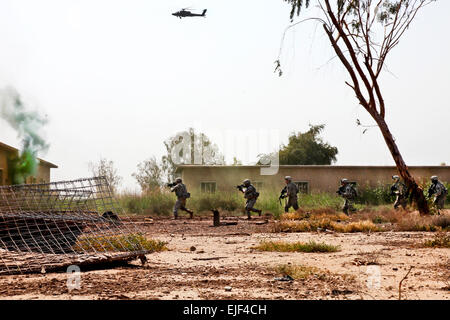 Ein US-Armee AH-64 Apache Kampfhubschrauber bietet Antenne Sicherheit, während Soldaten der irakischen Armee einen Angriff Luftbetrieb in Taji, Irak, 29. März 2010 durchzuführen. Amerikanische Truppen sind Unterstützung und Beratung von irakischen Sicherheitskräften und wird dies auch weiterhin tun. Der oberste Kommandant der US-Streitkräfte sagte April 18, die sie zu Stabilisierungsoperationen, Übergang und das letzte US-Kampf-Outfit wird das Land bis Ende August verlassen. Stockfoto