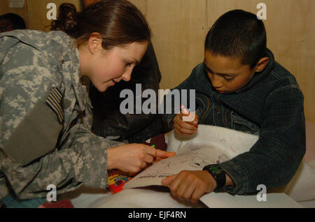 080225-F-5090B-001 - BAGRAM AIRFIELD, Afghansitan, Armee Sgt. Heather Slater, bereitgestellt von den 367th Military Police Company, Horsham, PA, Schuhen einen afghanischen junge an wie Verwendung Buntstifte und eine Färbung im ägyptischen Krankenhaus hier 25 Februar buchen. Slater und mehrere andere Servicemembers aus dem 724. MP-Bataillon besucht stationär im Krankenhaus jeden Sonntag.  Senior Airman James Bolinger Stockfoto