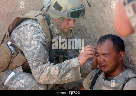 070410-A-9834L-012 SANGIN, Afghanistan - Special-Forces-Team Medic zugewiesen an die kombiniert gemeinsame spezielle Betriebe Task Force - afghanische gilt ein weiterer Soldat, Schrapnell Wunden von einer RPG-Explosion empfangen, während kämpfen Taliban-Kämpfer im Bereich Sangin Distrikt der Provinz Helmand April 10, medizinischen Behandlung. Der Soldat war in der Lage, weiter kämpfen, Minuten später. US Army Spc. Daniel Liebe Stockfoto