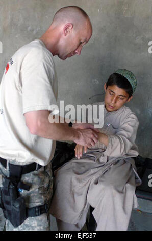 070414-A-9834L-027 SANGIN, Afghanistan - Sondereinsätze Physiotherapeut untersucht einen afghanischen Kind am Handgelenk während einer Mission medizinische Nothilfe im Zentrum Bezirk Sangin in der Provinz Helmand 14. April.  Mehr als 500 Afghanen erhalten medizinische Behandlung während der 3-Tages-MEDCAP. US Army Spc. Daniel Liebe Stockfoto