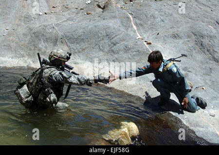 Afghanistan nationale Polizeioffizier hilft US Army 2nd Lt. Jonathon Reabe des Provincial Reconstruction Team aus nach vorne Operating Base Kalagush, aus einem Pool er verfiel während der Überquerung eines Baches während einer Patrouille von Balik in Nuristan Provinz von Afghanistan 14. Juni 2007.   Staff Sgt Michael Bracken Stockfoto