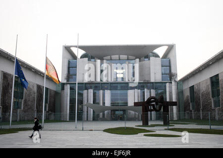 Berlin, Deutschland. 25. März 2015. Ein Fußgänger läuft von einer deutschen Nationalflagge sowie ein EU Flagge fliegt auf Halbmast in der Staatskanzlei zum Gedenken an die Opfer der abgestürzten Flugzeugs von Germanwings in Berlin, Deutschland, am 25. März 2015. Ein Airbus A320 der deutschen Low Cost Fluggesellschaft stürzte Germanwings mit 150 Menschen an Bord am Dienstag in Südfrankreich. © Zhang Fan/Xinhua/Alamy Live-Nachrichten Stockfoto