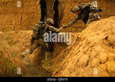 COMBAT OUTPOST MIZAN, Afghanistan--US-Army 1st Lt. Troy Peterson, Recht, Zugführer für 3rd Platoon, Fox Company, 2. Eskadron, 2. Stryker Cavalry Regiment, unterstützt seinen Funker, US-Armee Pfc Justin Cobbs, über eine Schlucht während einer abgesessene Patrouille in der Nähe von Combat Outpost Mizan, Mizan Bezirk Zabul Provinz, 16. August 2010. Die Patrouille konzentrierte sich auf das sprechen mit der lokalen Bevölkerung für Bedarfsanalysen und Vermessung der Sicherheit des Raumes. U.S. Air Force Photo/Senior Airman Nathanael Callon Stockfoto