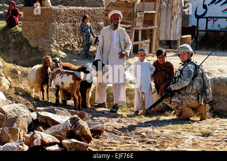 US Army Staff Sgt. Jeremy Fehr, direkt von der Iowa National Guard 734th Agri-Business Development Team ADT, spricht mit afghanischen Kindern und ihrem Großvater 24. Oktober 2010, während einem tierärztlichen Erhaltung Programm in Marawara District, Provinz Kunar, Afghanistan. Örtlichen Tierärzten behandelt fast 200 Ziegen, Schafe und Rinder. Die Iowa ADT zur Verfügung gestellt finanzielle Unterstützung, Qualitätskontrolle und Sicherheit während der Veranstaltung.  Kapitän Peter Shinn, US Airforce Stockfoto