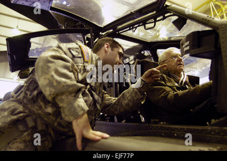 Chief Warrant Officer 2 Chad Remala eines Unternehmens, 3. Bataillon, 159. Angriff Reconnaissance Battalion, erklärt die co-pilot/Kanonier-Station von der AH - 64D Apache Longbow Hubschrauber Oberst i.r. Udo Lorenz, ehemaliger Kommandant der territorialen Verteidigung-Befehl, während eines Besuchs in Illesheim, Deutschland, Jan. 7. Lorenz war Teil einer Gruppe von prominenten deutschen Community-Mitglieder die Gelegenheit, Blick in das Leben der ein amerikanischer Flieger bei Storck Kasernen, durch Soldaten der 2. und 3. Bataillone, 159. Angriff Aufklärung Bataillone wurden. Elf Besucher aus der Region waren introd Stockfoto