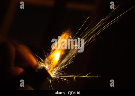 Funken von einer Hand gehalten in der Dunkelheit leichter Stockfoto