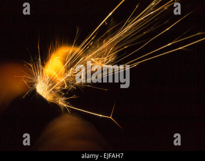 Closeup Details der Funken aus einer Hand gehalten in der Dunkelheit leichter Stockfoto